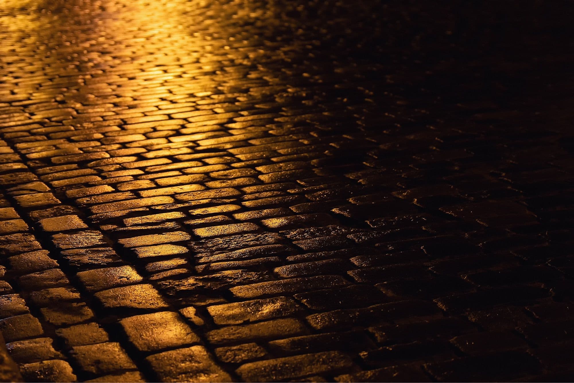 A brick road with a golden light reflecting off it